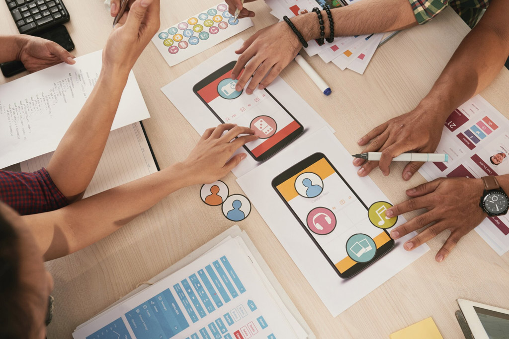 UX-designer-sketching-a-website-wireframe-on-paper-at-desk-photo