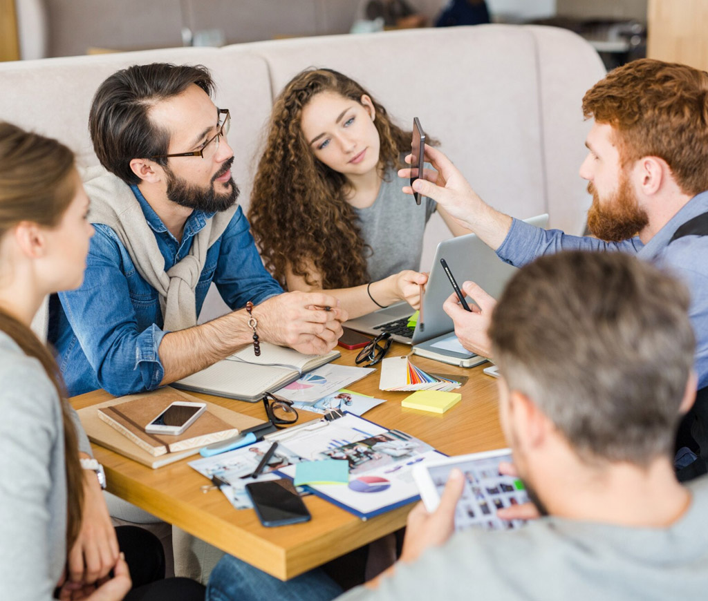Web-design-and-UX-strategy-team-collaborating-around-laptop-photo